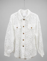 An off-white lace button-up shirt jacket with brown buttons, displayed on a clear hanger against a light gray background.